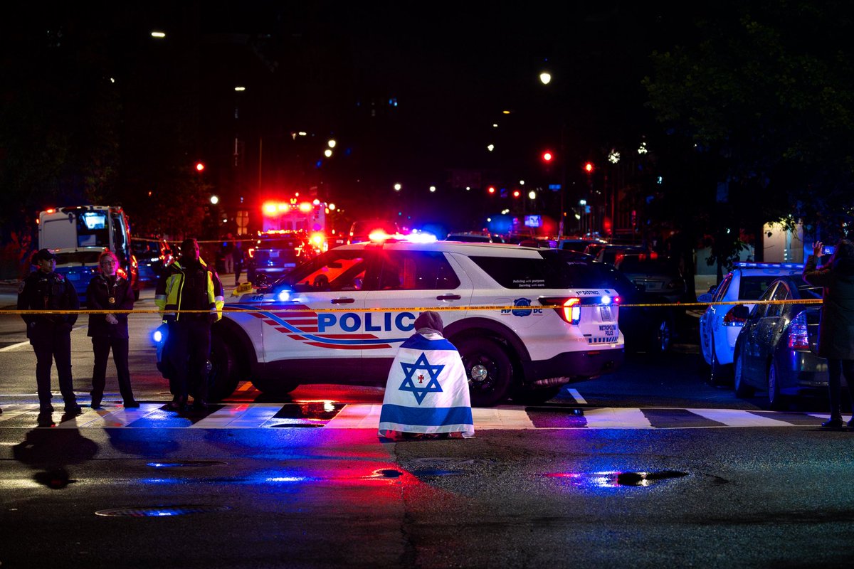 A bystander prays near the Capital Jewish Museum late Wednesday in Northwest Washington. Two Israeli Embassy staff were shot and killed near the museum after attending an event hosted by the American Jewish Committee. (Tom Brenner / For The Washington Post