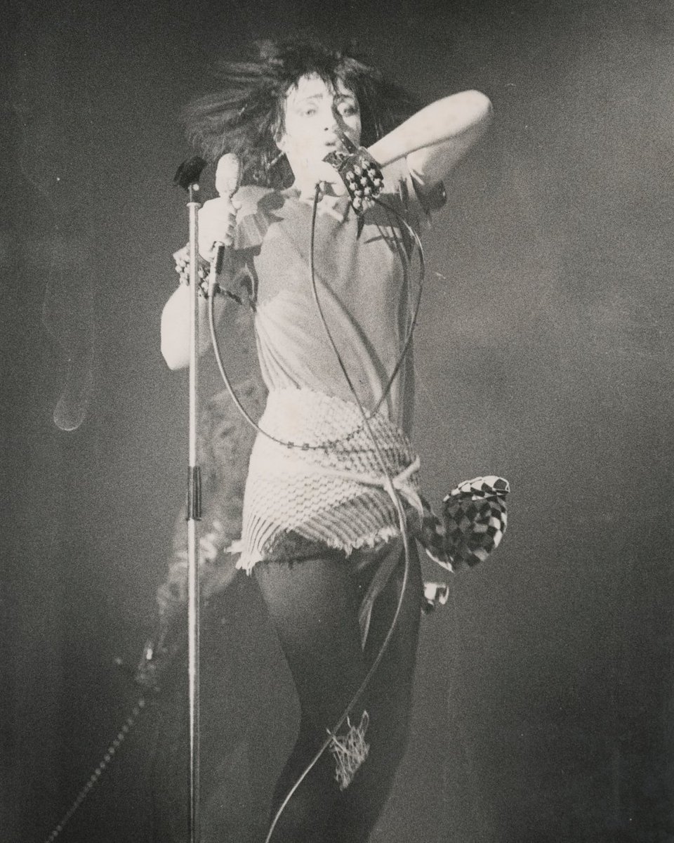 Emerging from the post-punk shadows in the 1970s, Goth was a subculture defined by its dark fashion and haunting melodies. Siouxsie Sioux, the lead singer from Siouxsie and the Banshees, epitomises this with her daring style and distinctive voice.

📸 © by Pennie Smith, 1970s