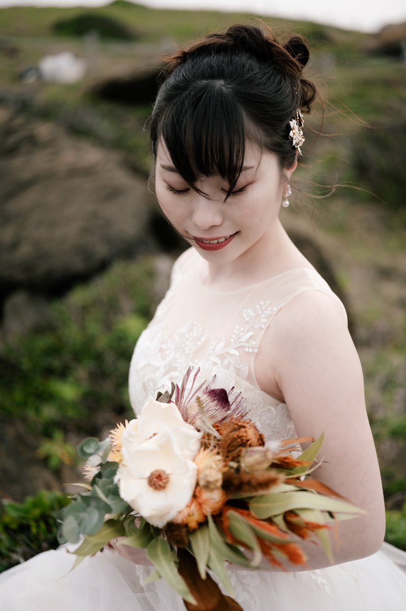 風が頬をなで、髪を揺らす。
潮の香りが、かすかに漂う。
岩肌の上、柔らかなドレスが静かに広がる。

乾いた空、くすんだ海に
華やかに咲く。

——花嫁ポートレート