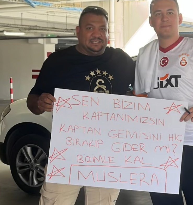 Victor Osimhen'le roman oynayan İzmirli taraftarımız, takımımızı havalimanında "Bizimle kal Muslera" pankartıyla bekliyor.