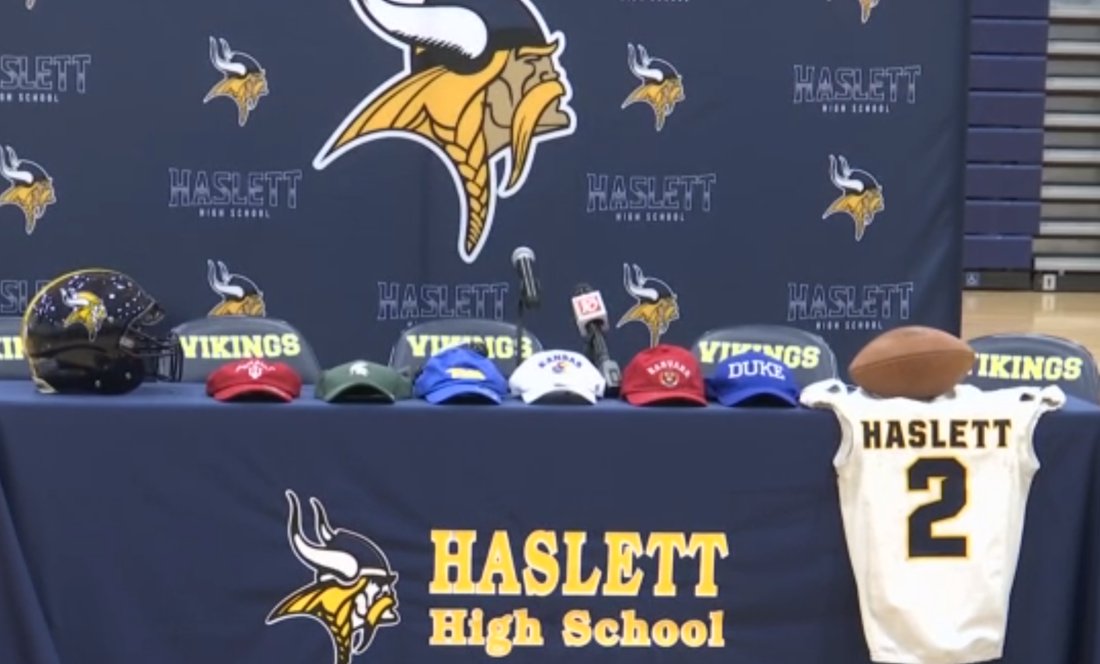 The stage is set for Kory Amachree's announcement. Six hats on the table and the KU hat fourth from the left. #kufball