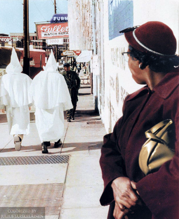 AfricanArchives's tweet photo. A black woman watches as robed Klansmen walk in downtown Montgomery, Alabama, prior to a cross burning rally that night, 1956. https://t.co/IOIIhJlBqG
