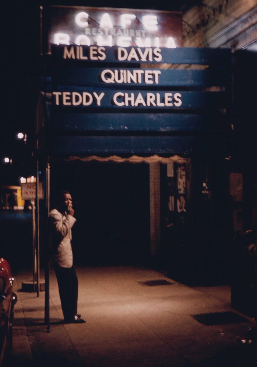 Miles Davis smoking a cigarette under the marquee of the jazz club Cafe Bohemia in New York City (1956)