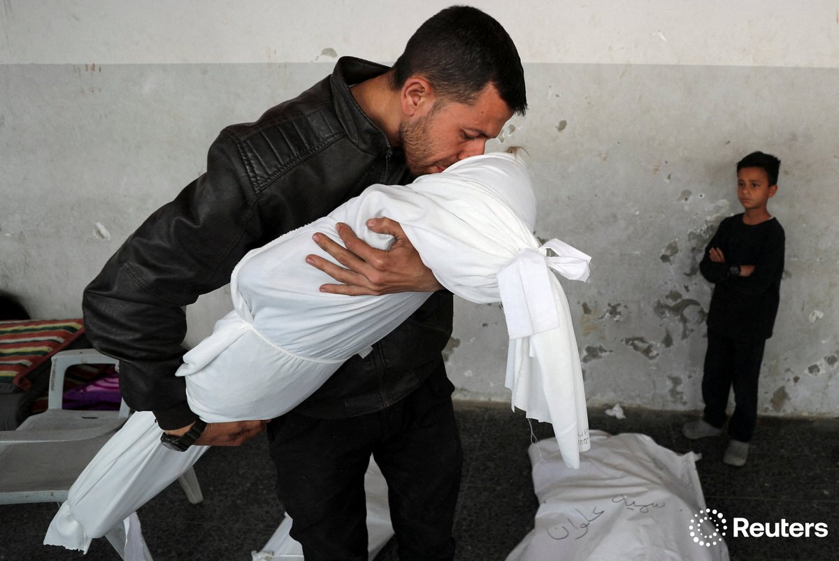 A Palestinian man kisses the body of his nephew Nour Nabhan, 5, who was killed in an Israeli strike, at Al-Ahli Arab Baptist hospital, in Gaza City. More photos of the week: reut.rs/3H6ZdeV 📷 Mahmoud Issa