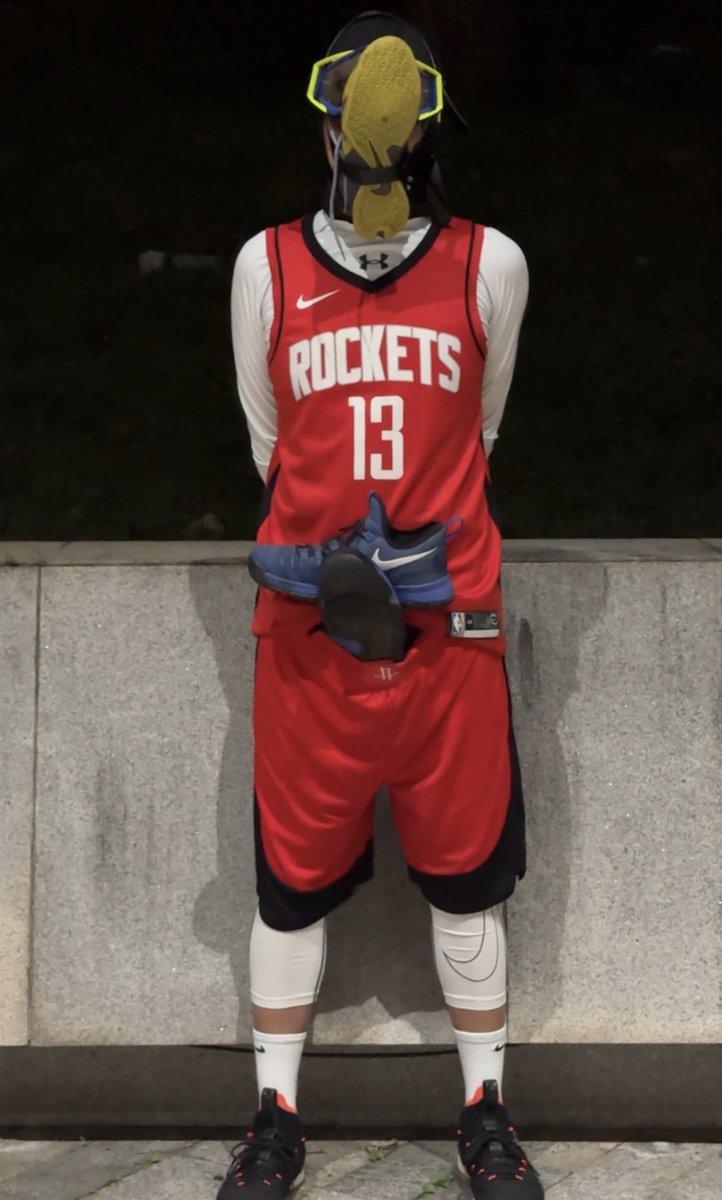 在体育公园正门口的射灯下，红色球服配白色的紧身衣...