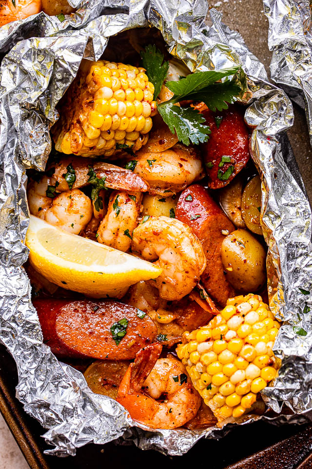 This Grilled Shrimp Boil in Foil Packets is a flavor-packed meal that's easy to make on the grill or in the oven! This hearty dinner is filled with perfectly seasoned potatoes, shrimp, sausage, more. #MemorialDay  #camping diethood.com/grilled-shrimp…