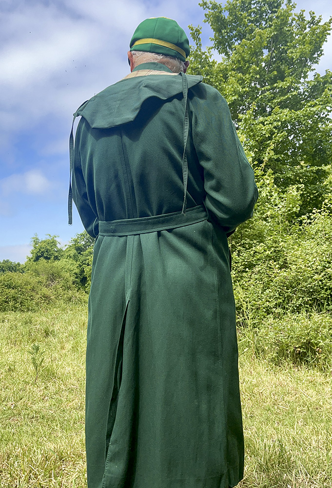 Boy in his junior schoolgirl's gaberdine raincoat. 

schooluniform raincoat