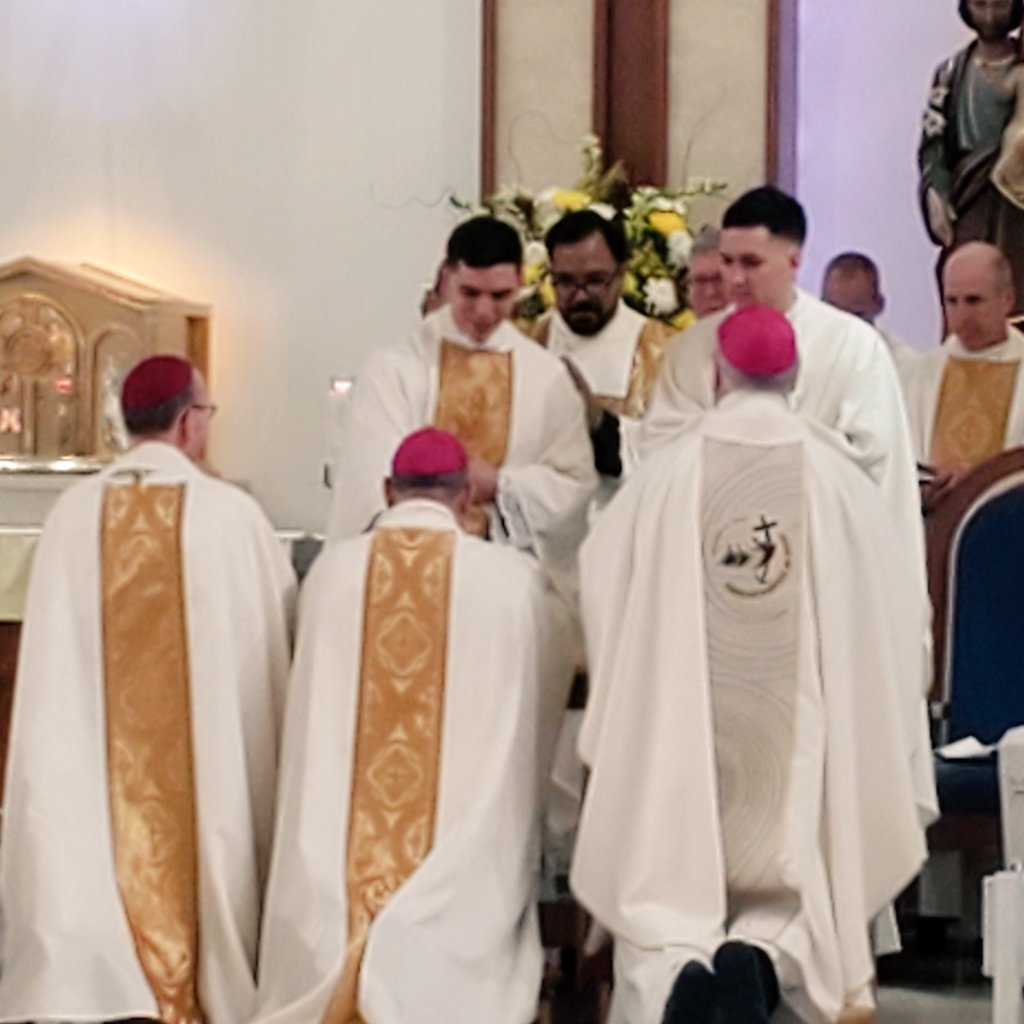 Two new #priests for <a href="/PhoenixDiocese/">Phoenix Diocese</a>! Fr. Jacob Chavez, left, standing, and Fr. Connor Companik give #firstblessings to, from right, kneeling, Bishop John Dolan, Aux. Bishop Eduardo <a href="/bishopnevares/">Eduardo Nevares</a> and Bishop Emeritus Thomas Olmsted after their #ordination at All Saints Church.
