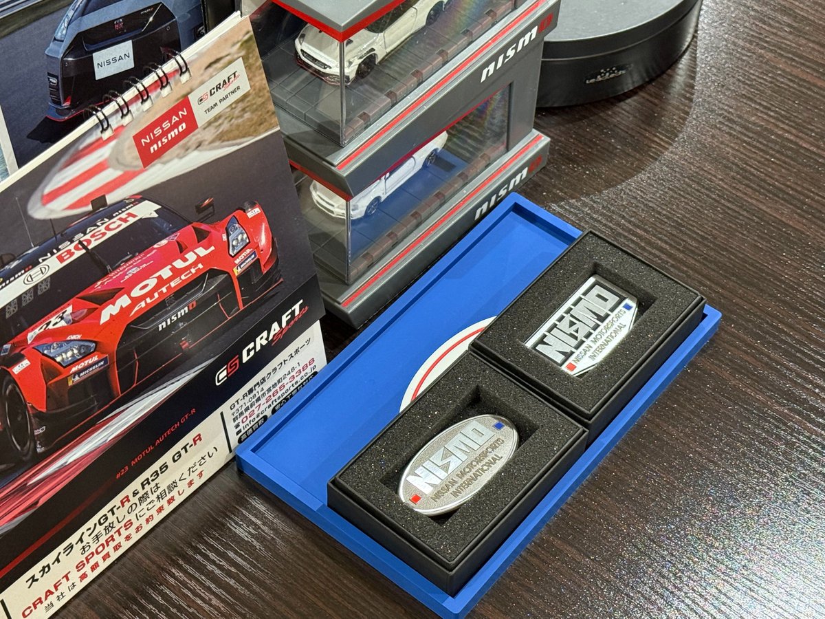 GFR_Owner's tweet photo. 以前から注文していたNISMO40周年記念のパーツ類が続々届きました。

メインがLMGT4の旧ロゴのホワイトです。9.5J＋12の18インチ仕様で、今回は展示用に1本だけです。BNR34用には隣の10.5j仕様のマシニング仕様を履かせます。

エンブレム類も届きまして、かつての270Rや400R時代を彷彿させる旧デザインの仕様です。裏面に両面もあるので、内外装に貼れる仕様です。

上記2点ですがGFRブース@GFR_SC内に展示しております。湾岸ミッドナイトの特典バナパス等も飾っていますので、来店時に是非ご覧になっていただけると嬉しいです。