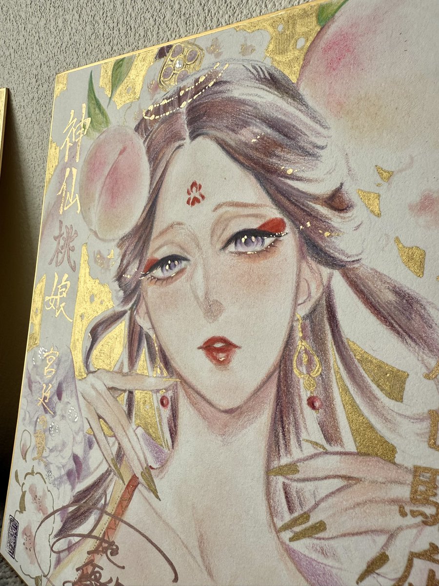 #神仙桃娘 サイン色紙
描き上げた直後に自宅で撮影🍑

見る角度や光の当たり方によって扎熱（ザラ）の表情に変化が出るように仕上げています✨
1、2枚目は配置を逆転させだだけですが、わりと表情の印象が違うと思いませんか？

画材 : 色鉛筆＆金マーカー（瞳のベースにのみアルコールマーカー）