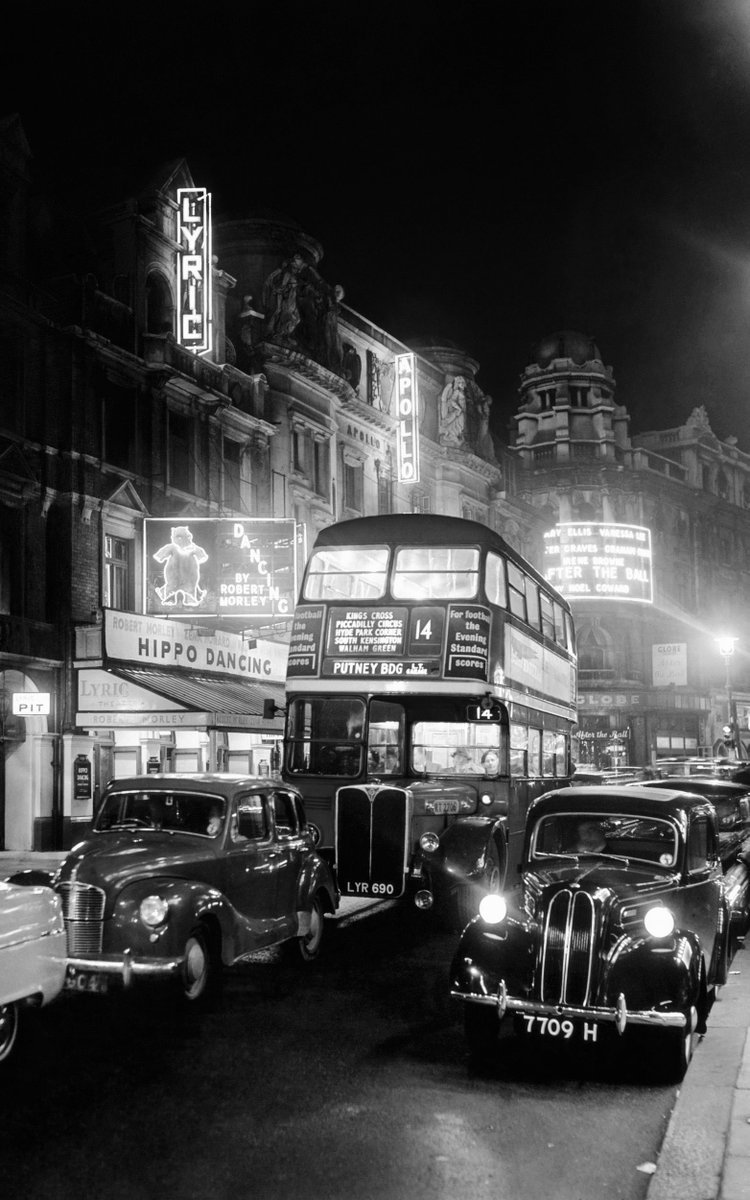 A magnificent photo of Shaftesbury Avenue with cars glowing beneath an illuminated Lyric Theatre. London, 1954.