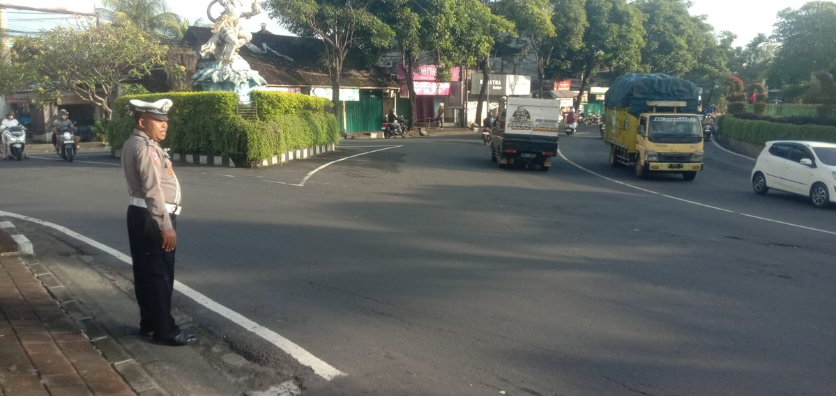 Personil Satlantas Polres Badung melaksanakan pengaturan dan penyebrangan di simp. Sempidi