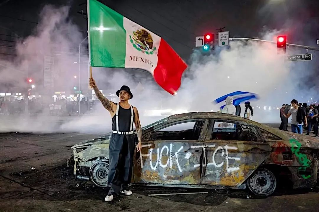 Un manifestante en el barrio de Compton de Los Ángeles, California, ondea la bandera de 🇲🇽 junto a restos de un automóvil quemado y cubierto de grafitis que expresan el desprecio contra el ICE, quienes han emprendido redadas violentas en contra de inmigrantes 😡 .
📷Ringo Chiu