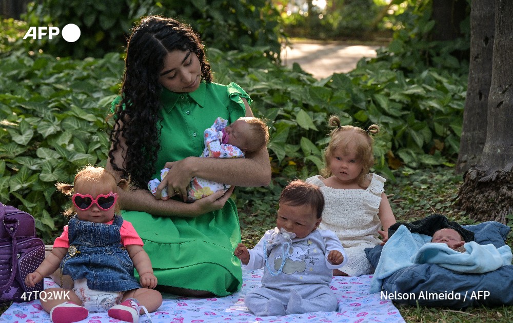 Gabi Matos looks the quintessential doting mum as she changes Ravi's nappy, cooing reassuringly as he stares up at her. Ravi is a hyper-realistic doll with an eerie resemblance to an actual infant <a href="/Carlos_Fabal/">Carlo Fabal</a> <a href="/lacursilucia/">Lucía Lacurcia</a> 
u.afp.com/Sp29