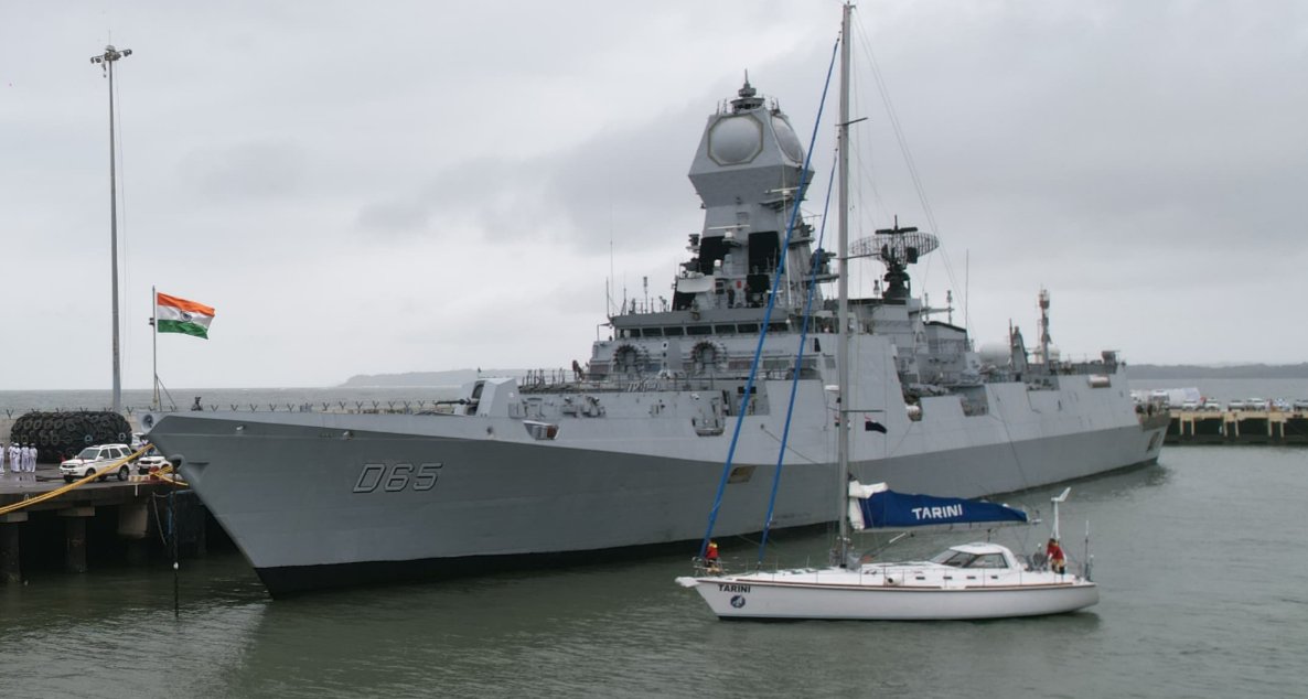 Beauty and the Beast ... the tiny sailboat INSV Tarini with Lt Cdr Roopa A and Lt Cdr Dilna K sail past INS Chennai as they return home after circumnavigating the globe.  Extraordinary achievement for these remarkable sailors! #NavikaSagarParikrama_II शं नो वरुणः!