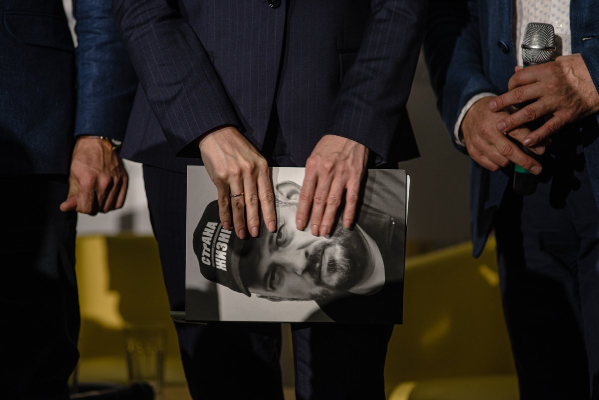 Tsihanouskaya's tweet photo. I carry Siarhei’s photo everywhere. When people ask how he is doing, I have no answer for them.

Five years in prison. Two years in total silence.

Our children grow up missing their dad. 

But the regime hasn’t broken us. We still hope. We still fight. We will never give up. https://t.co/CCHkWQTs6q