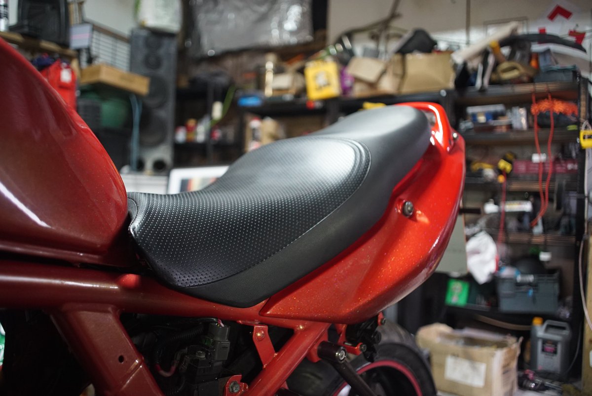 The seat of my Suzuki Bandit barn find had a factory fitted , red and black real leather cover put on it.
Which someone paint black.. with a brush..
I took the cover off and here is the result.