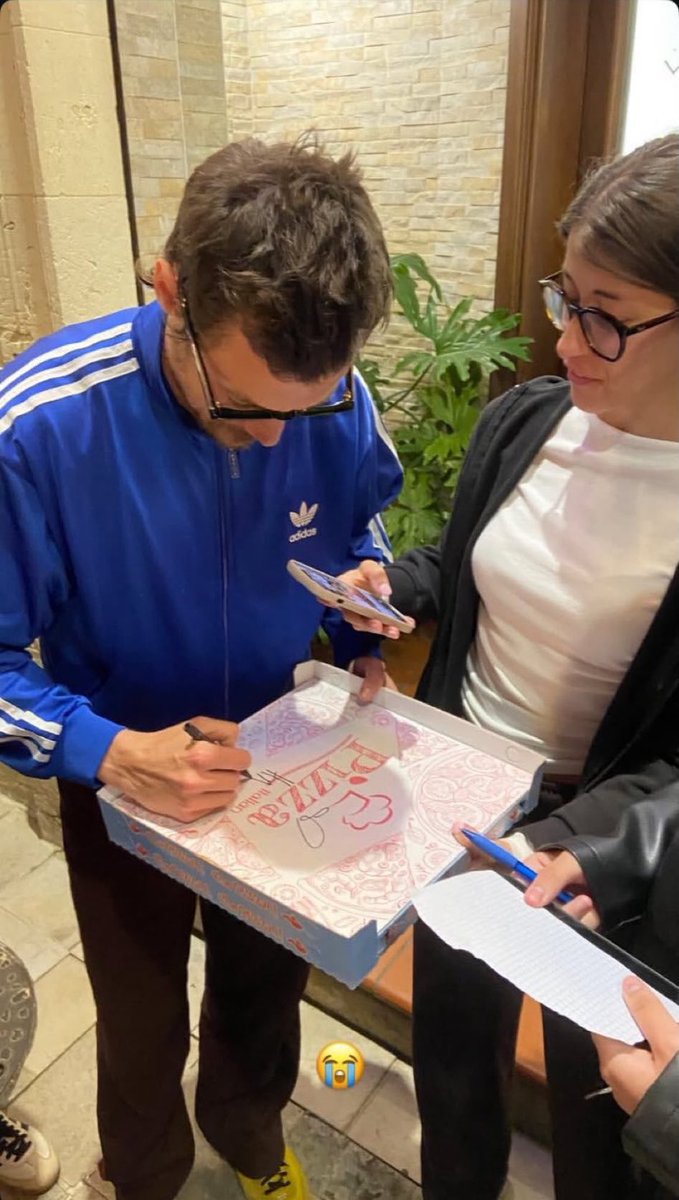 Harry signing a pizza box for a fan in Italy recently!