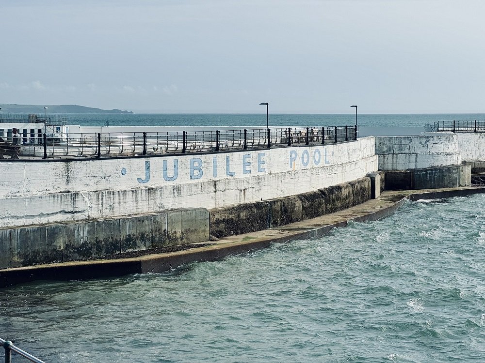 ArchHFundEng's tweet photo. News splash – #AHFsupported @JubileePoolPZ turns 90! 📰 🌊
The historic lido first opened in 1935 & remains at the heart of Penzance's cultural & recreational life today.
Tomorrow, it will mark its 90th anniversary with a splashing celebration.
➡️ https://t.co/zSkTrLPLlf https://t.co/9XXeY8FBDG