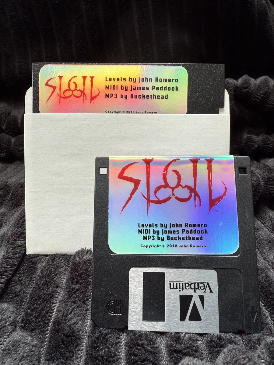 romero's tweet image. Ships next week! The original SIGIL in a new embossed foil box w/real 5.25" and 3.5" disks. Runs on classic machines & you get a digital download! New merch includes three pins, a foil sticker sheet, cover art poster and cinch bag. While supplies last. Romero.com.