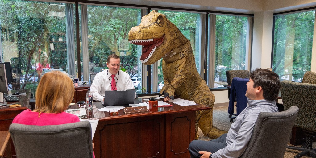 NCTreasurer's tweet image. DST Chief of Staff Eric Naisbitt doing his best not to go full Jurassic pork chop while wrangling legislative liaisons. T-rex stopped by the office today to celebrate the retirement- after 33 years- of work for one of our RSD division heads.  Congratulations! #ncpol #retirement