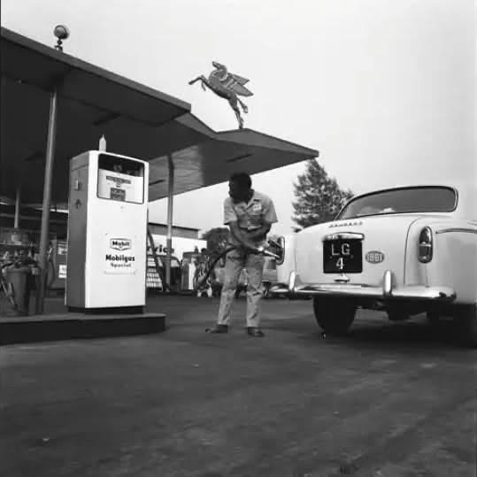 NigeriaStories's tweet photo. A fuel attendant filling up a customer's Peugeot 403 automobile at a Mobil Service Station in Lagos, January 1961 https://t.co/l38CAfsUVa