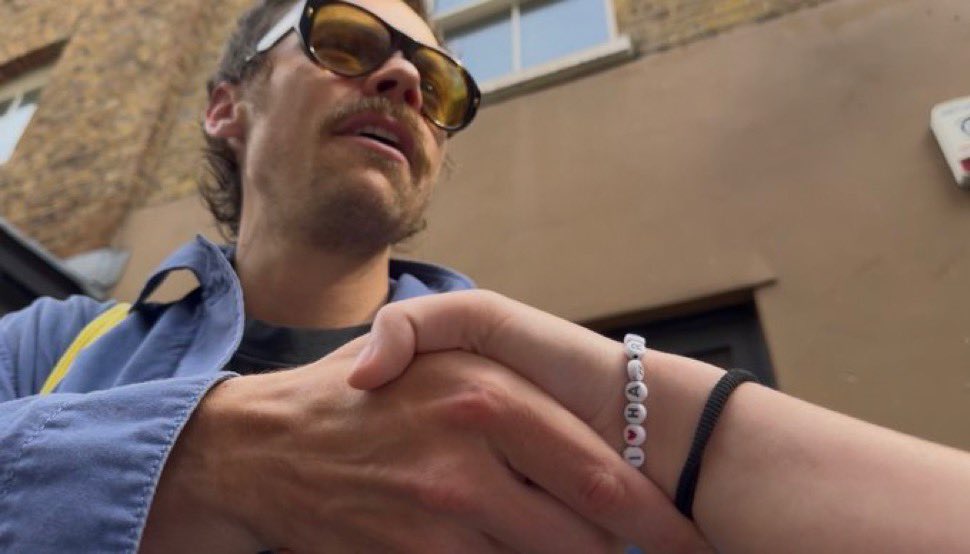 the i ❤️harry bracelet whilst shaking his hand is so poetic