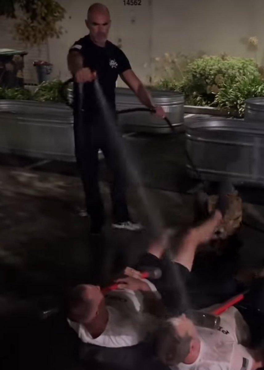 the wildest activity that men have to do at one of these camps is lay on the ground, hold sledgehammers, kick their feet and get sprayed with water by “pain enforcers”