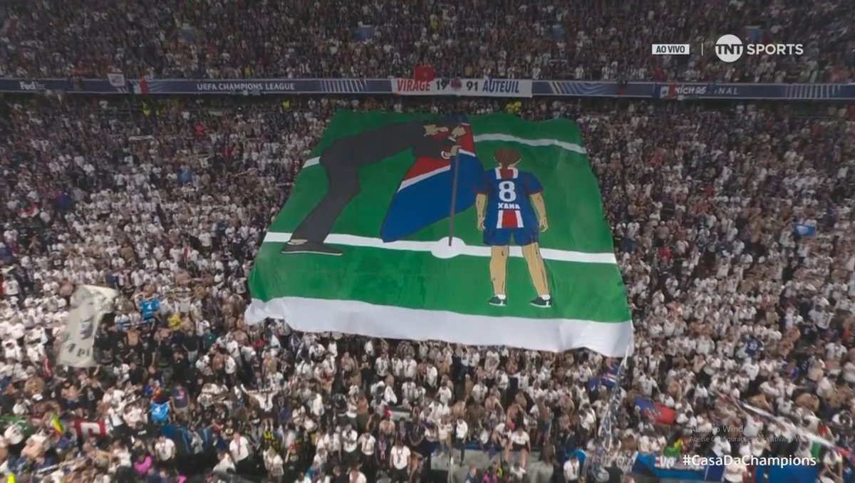 LINDO, LINDO, LINDO! Torcida do PSG exibe bandeirão em homenagem a Xana e Luis Enrique.

📸 Reprodução/TNT
