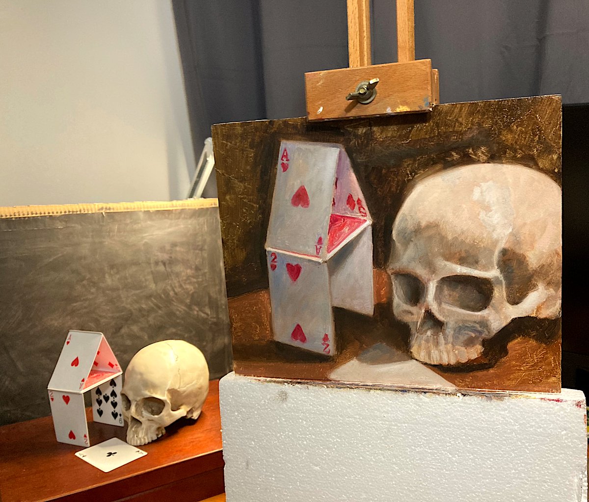 flakewhyte's tweet image. #stilllife wip oil painting with a skull and a card tower. its 8*10"