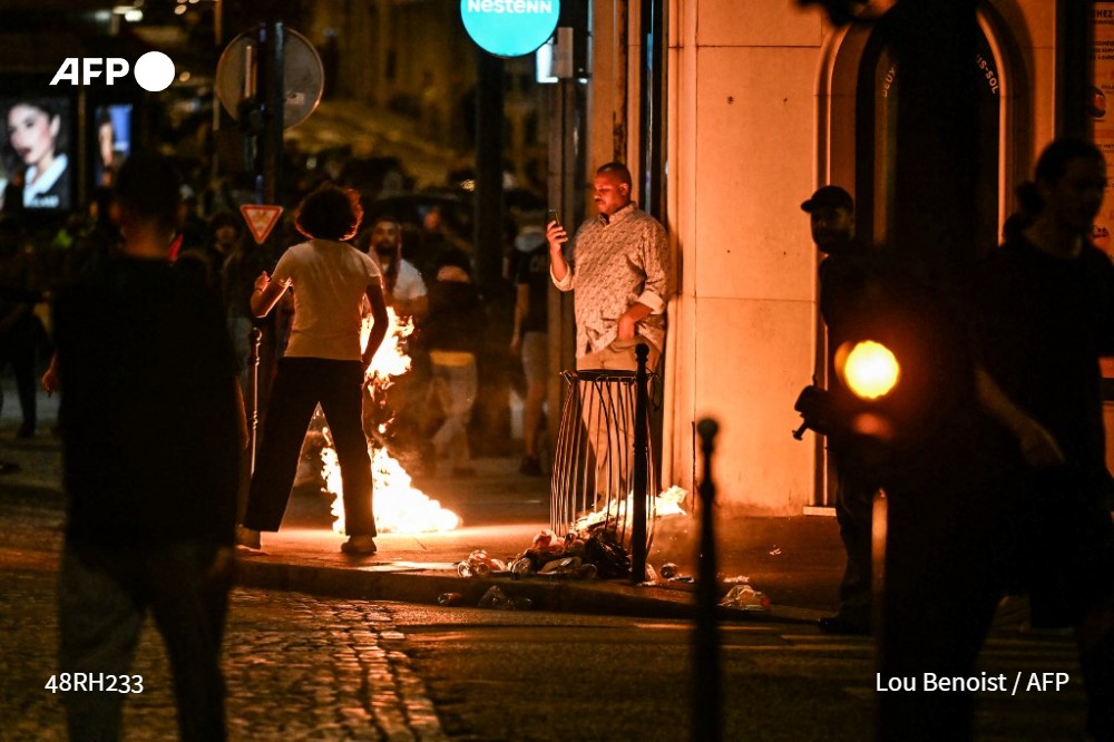 A rubbish bin is set on fire on the Champs-Elysees avenue in Paris on May 31, 2025 as Paris Saint-Germain supporters celebrate their team winning the Champions League final against Inter Milan in Munich