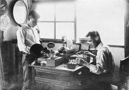 文化◆1日、大阪の早川徳次が、自作の鉱石ラジオで受信を試す＝写真右＝。大阪放送局(JOBK)の音声が明瞭に聞こえ、肩を抱いて喜ぶ。外国製品の半額以下となる3円50銭で市販を開始し、爆発的に売れる。ブランド名はラジオが明瞭に聞こえることから、「シャープ」とする。　＝百年前新聞社 (1925/06/01)