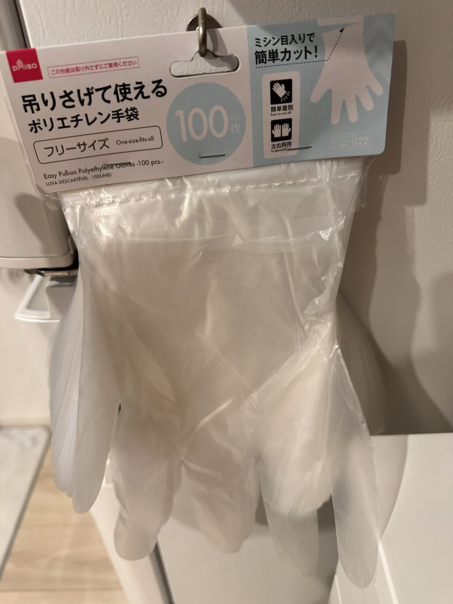 ダイソーパトロール趣味なんだけどこれよこれ。100枚入りの手袋。冷蔵庫にかけておけばお肉とか触って片手塞がってる時でも手袋装着余裕、洗濯機の横にかければお風呂の排水溝ネット捨てる時直接触らずに丸めてゴミ箱直行で済む。箱から手袋取り出すより手間取らないからタイパ良いのよ