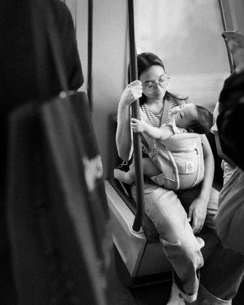 monochromebob's tweet photo. A whole world in her arms.
No spotlight, no stage.
Just a morning train and a mother’s quiet resolve.

#streetphotography #bnwphoto #blackandwhite #motherhoodinmotion #visualpoetry #everydaylife #monochromebob #singaporestreetphotography https://t.co/BLYly7rymb