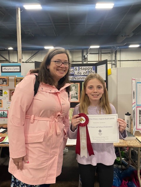 Mary MacDonald Pickering, presents 2 Heritage Fair prizes:
(1) Felicity MacDonald “The Good &amp; Happy Life of My Old Nanny”, Eliot River Elementary
(2) Ezra Arsenault, “Orella Arsenault: Predestined to be a Teacher”, Homeschool Group
Congratulations Felicity and Ezra!