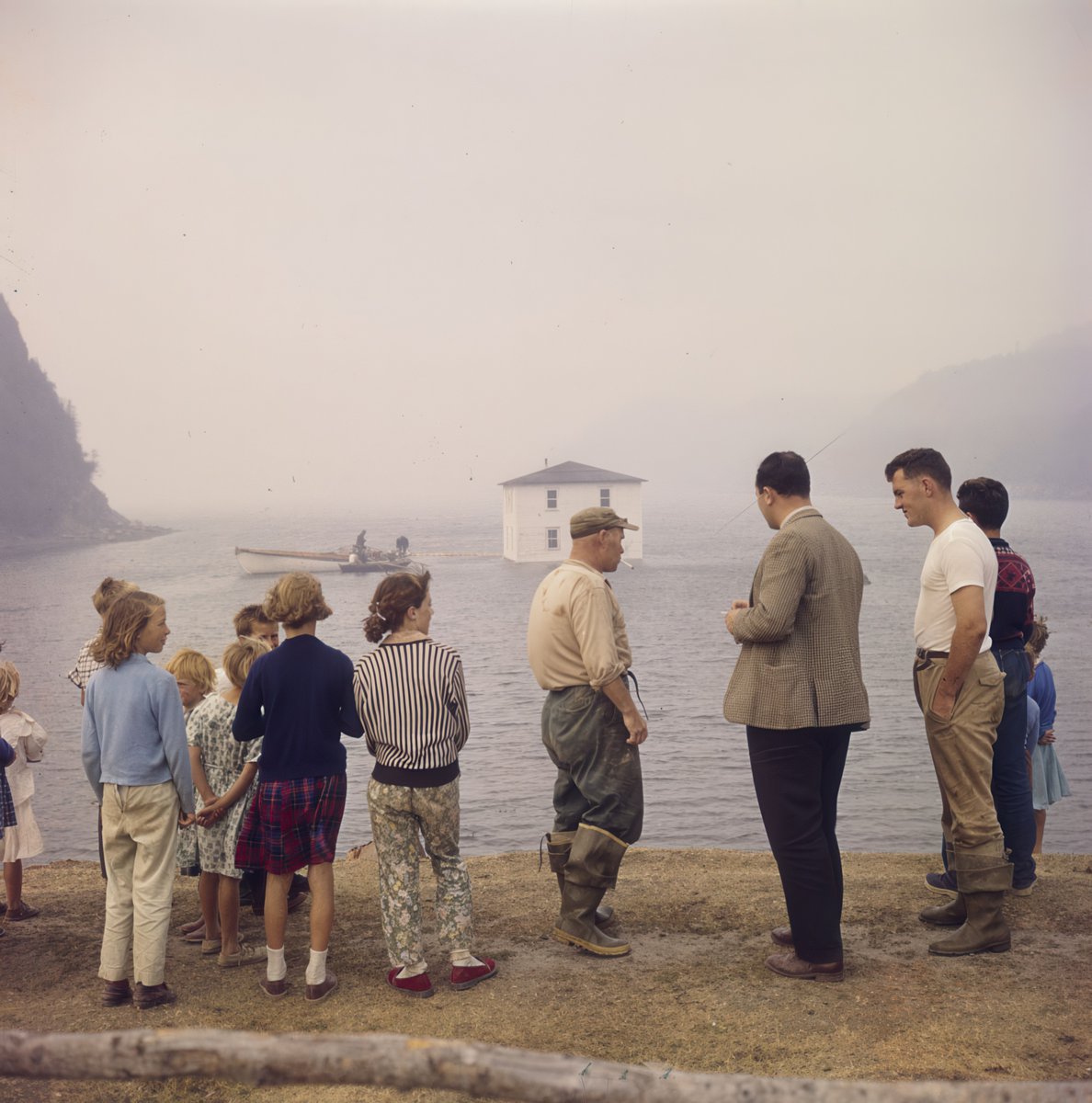 A house being floated from Silver Fox Island, Bonavista Bay, to Dover, Newfoundland in 1961. credit: library &amp; archives of canada