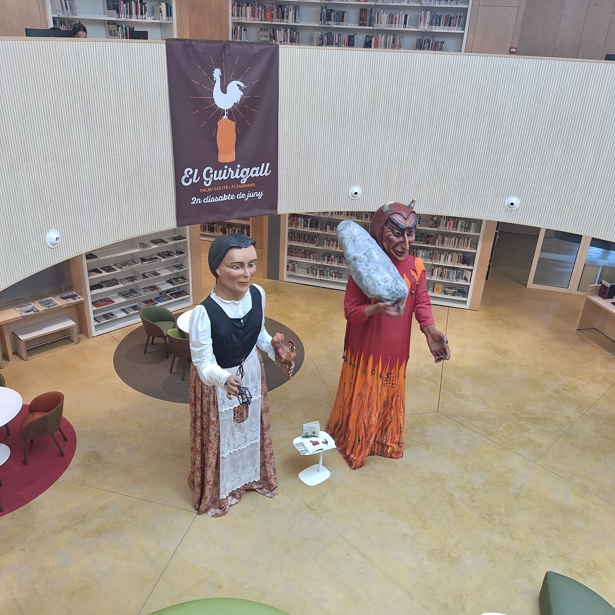 La biblioteca l'Alzina de #PsiP rep la visita dels Gegants de Palau: La Masovera i el Dimoni, per convidar-nos a la Festa del Guirigall