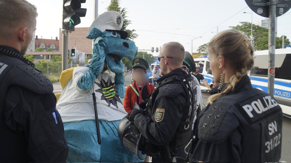 An der Dimitroffwacher der Polizei  nahm man ihn in die Maßnahme wegen dem Hohheitszeichen der Polizei  auf seinem kostüm.