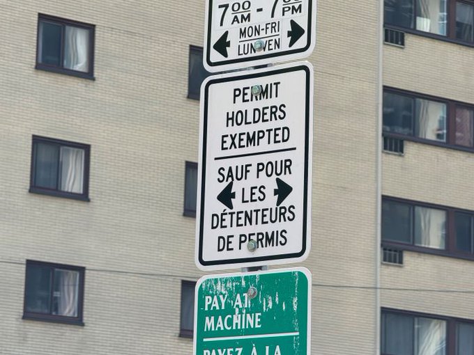 Sign on post reading, “Parking permit holders exempted.”