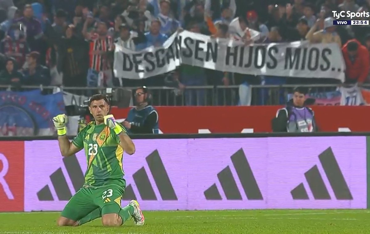 Portillo_Yuli's tweet photo. El Dibu Martínez y la bandera de los hinchas argentinos haciendo alusión al tweet de Arturo Vidal para sus hijos, que siguen esperando que clasifique a un Mundial.

"DESCANSEN, HIJOS MÍOS". https://t.co/sUNuq6tWmq