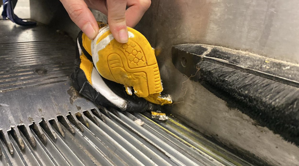 zapatilla infantil atrapada en una escalera mecánica