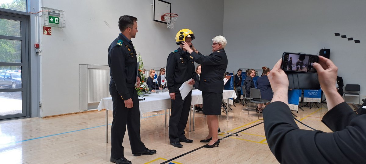 Pelastusopiston rehtori jakaa kurssien priimuksille palkinnot.