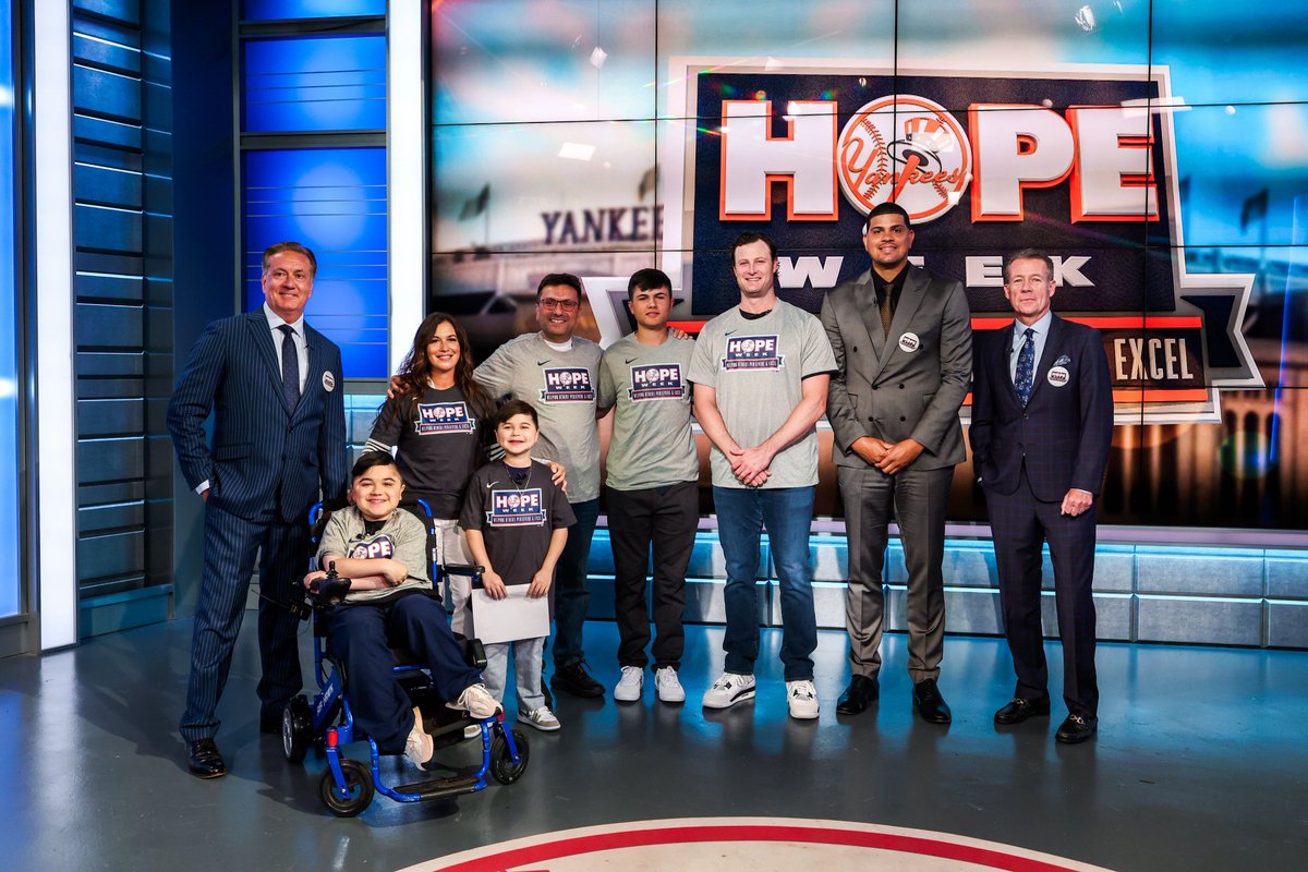 Yankees's tweet photo. For Day 4 of #HOPEWeek, we are honoring Carmine and Vincent Gagliano, two young Yankees fans from Brooklyn battling Duchenne muscular dystrophy (DMD), a devastating, progressive muscle disease that causes muscles to become weaker over time until it affects the whole body.
The sports-centric brothers’ diagnoses prevent them from playing the games that they love, but they’ve stayed involved through announcing.
Earlier this month, Carmine and Vincent, along with their family members visited the @YESNetwork studios. There, the boys were surprised by Yankees pitcher @GerritCole45, and met host @boblorenz and analysts @JackCurryYES and @DBetances68.