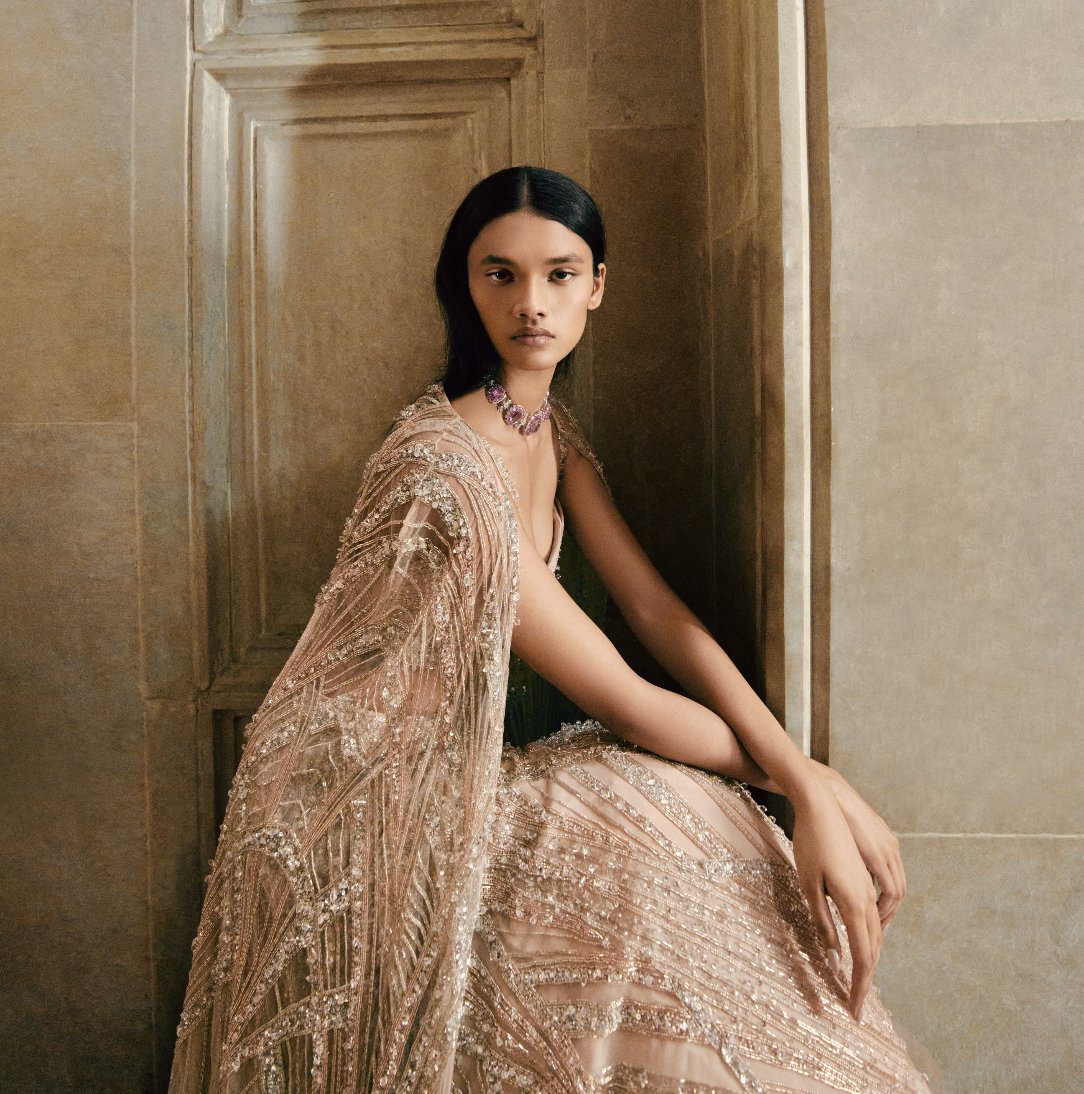 Summer Haze is a poetic interplay of tradition and innovation, reimagining the cocktail moment in haze champagne. The ensembles are adorned with tonal glass beads, reflective crystals and shimmering sequins. Meticulously handcrafted by Indian artisans, the collection captures the