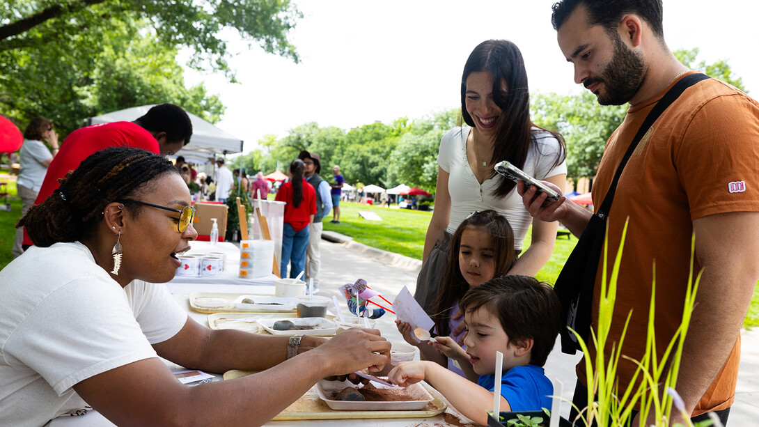 Photo of the Week: Bellodgia Roberson, a graduate student in agronomy and horticulture, helps 3-year-old Jasper Molina create a soil profile during the East Campus Discovery Days and Farmers Market event on June 14. go.unl.edu/cg2n #Nebraska #UNL #LNK