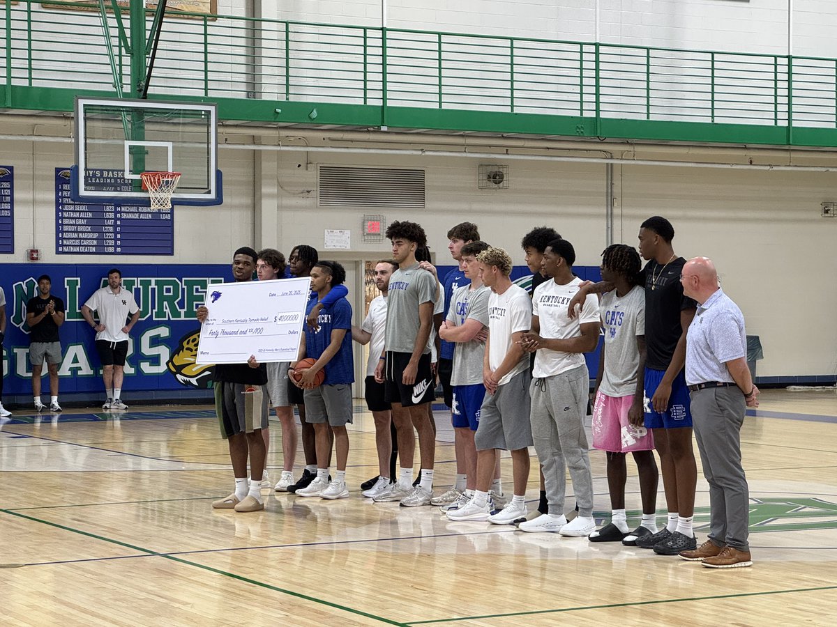 Otega Oweh and the Kentucky basketball team present a check for $40,000 for Southern Kentucky Tornado Relief as part of their satellite camp at North Laurel High School in London.