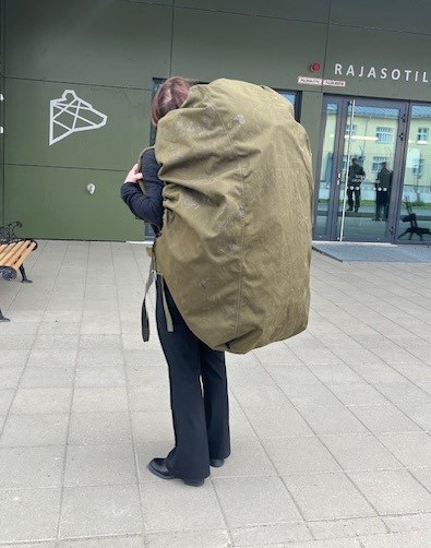 Föredragande vid JO:s kansli inspekterade i dag Norra Karelens gränsbevakningssektion i Onttola. I morgon fortsätter inspektionen vid Karelska brigaden i Vekarajärvi. På bilden provar föredraganden en 30 kg tung ryggsäck som ingår i gränsjägarens grundutrustning. #oikeusasiamies