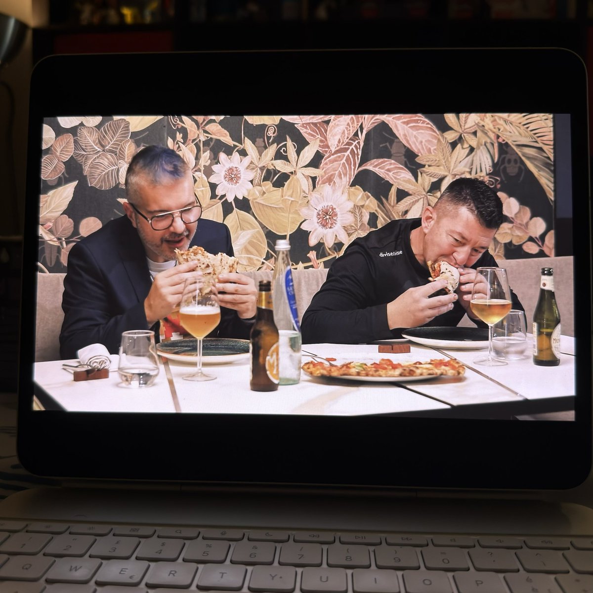Tanzen's tweet photo. ✍️ Sono su Amazon Prime Video, nella serie di Errico Porzio

Ma, invece di autoincensarmi, vi lascio la recensione con giudizio ✌️

Il percorso mediatico di Errico Porzio è cominciato in piena pandemia con l'esplosione su TikTok, per poi estendersi su Instagram ed una serie di iniziative che proprio pochi giorni fa si sono materializzate in una serie a puntate su Amazon Prime, chiamata "**Strapizzami di Coccole**", nome già utilizzato in una rubrica su Youtube con protagonista sempre Errico nel 2017.

Il pizzaiolo-imprenditore ora anche presentatore ha sempre utilizzato la sua accresciuta popolarità mantenendo il rapporto diretto con il pubblico e sviluppando la parte imprenditoriale senza essere intaccato da quel virus molto comune che si trasforma in snobismo e perdità del contatto con la realtà.

Le prime quattro puntate seguono un canovaccio piuttosto classico per i programmi del genere: ogni puntata è dedicata ad uno stile differente di pizza, e vede come protagoniste tre pizzerie suggerite ad Errico Porzio da altrettanti blogger, food influencer o giornalisti. Ciascuna sottopone il proprio cavallo di battaglia e una pizza speciale dedicata ad un personaggio iconico della cultura napoletana; a fine puntata Errico Porzio decreta il vincitore secondo la propria preferenza.

Nella terza puntata, all'interno nel segmento dedicato alla **Ruota di Carro**, ci sono anche io (discreto nelle parti naturali/di giudizio, da rivedere in quelle recitate); Errico Porzio anche in questo fondamentale si trova oramai a suo agio, in un prodotto confezioanto su misura per lui e rivolto soprattutto al suo pubblico. 

Dopo la visione si evince il nobile scopo di segnalare alcune pizzerie meritevoli in giro per Napoli, impreziosito da alcuni aneddoti legati alla città partenopea.
I difetti maggiori sono imputabili alla fase di montaggio, che mi è parso un po' troppo pigro nel rendere le puntate ritmate ed equilibrate in ciascuna scena, con alcune sequenze troppo lunghe e monocorde e la completa assenza di grafiche per i protagonisti e per gli ingredienti delle pizze realizzate, che avrebbero reso le puntate ancora più godibili!