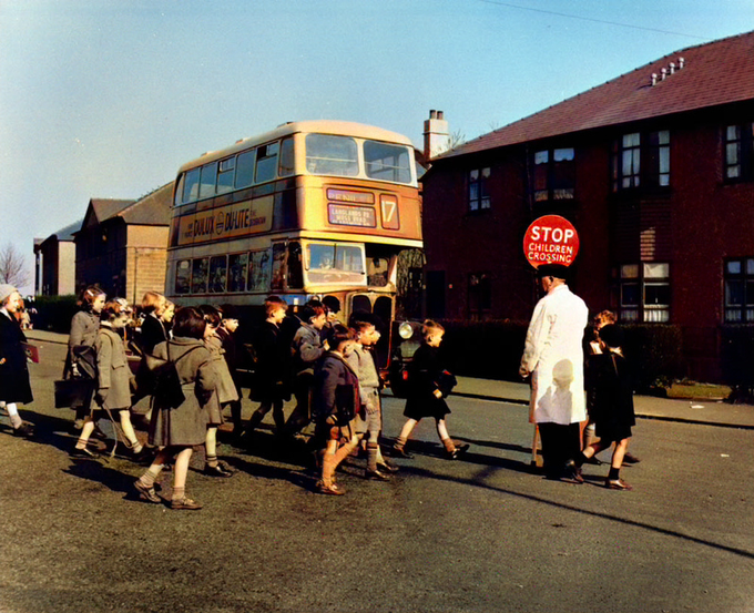School Crossing Patrol. The Driver of the No 17 Bus to Penilee waits patiently for the Children to cross the Road, Glasgow 1955 To View More Great Old Photos Of Old Glasgow, Visit https://OldGlasgow.com