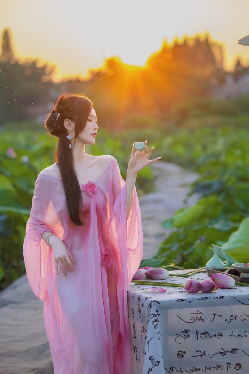 荷塘暮霭拂纱轻，素手擎瓯对晚晴。🍶
若引易安词笔意，一襟幽绪共波平。🌈